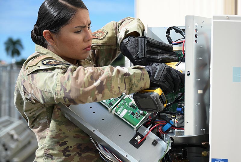 Female military personnel computer board repairs